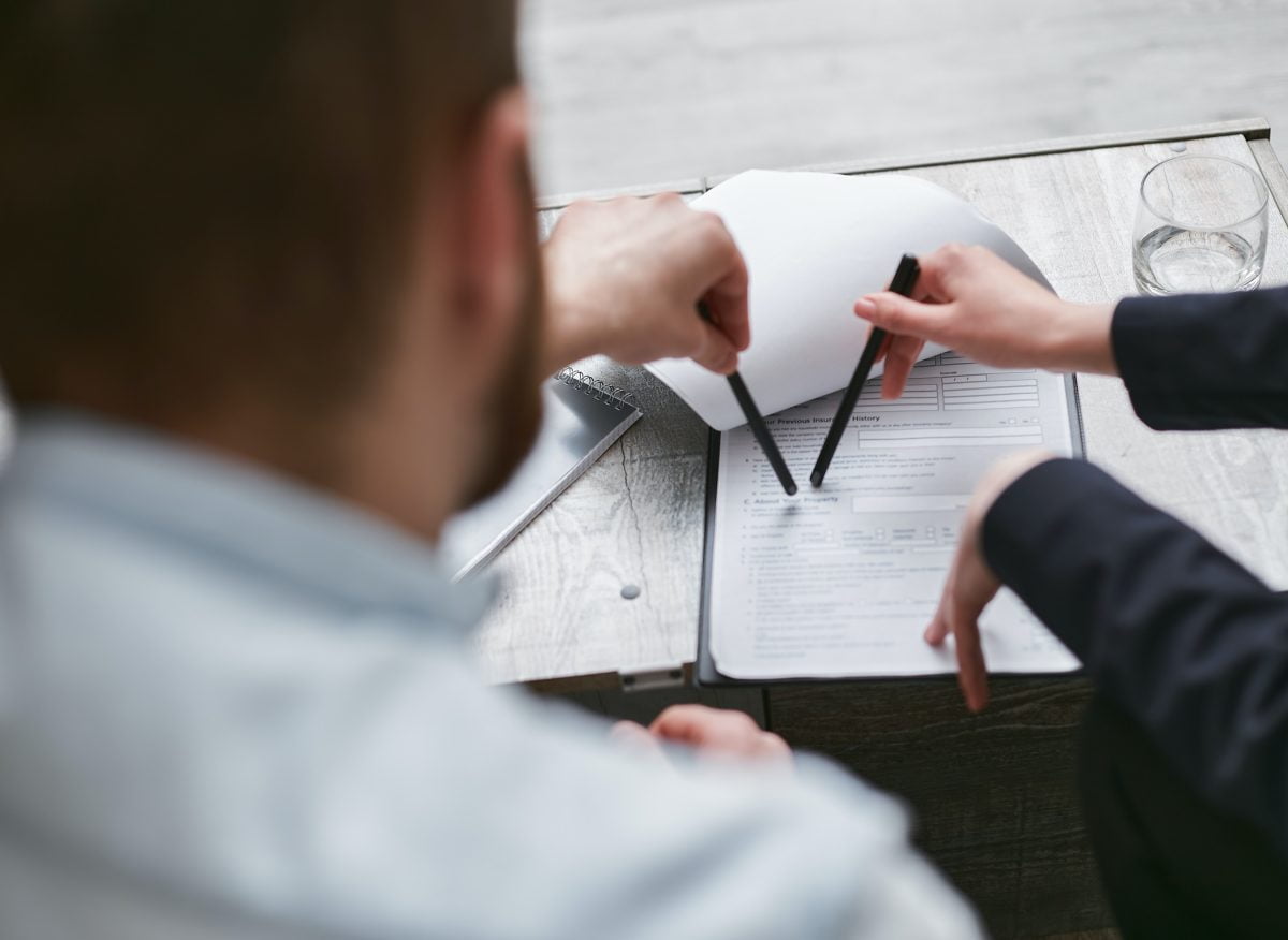People pointing at a contract and pointing with pens , Settlement Agreement