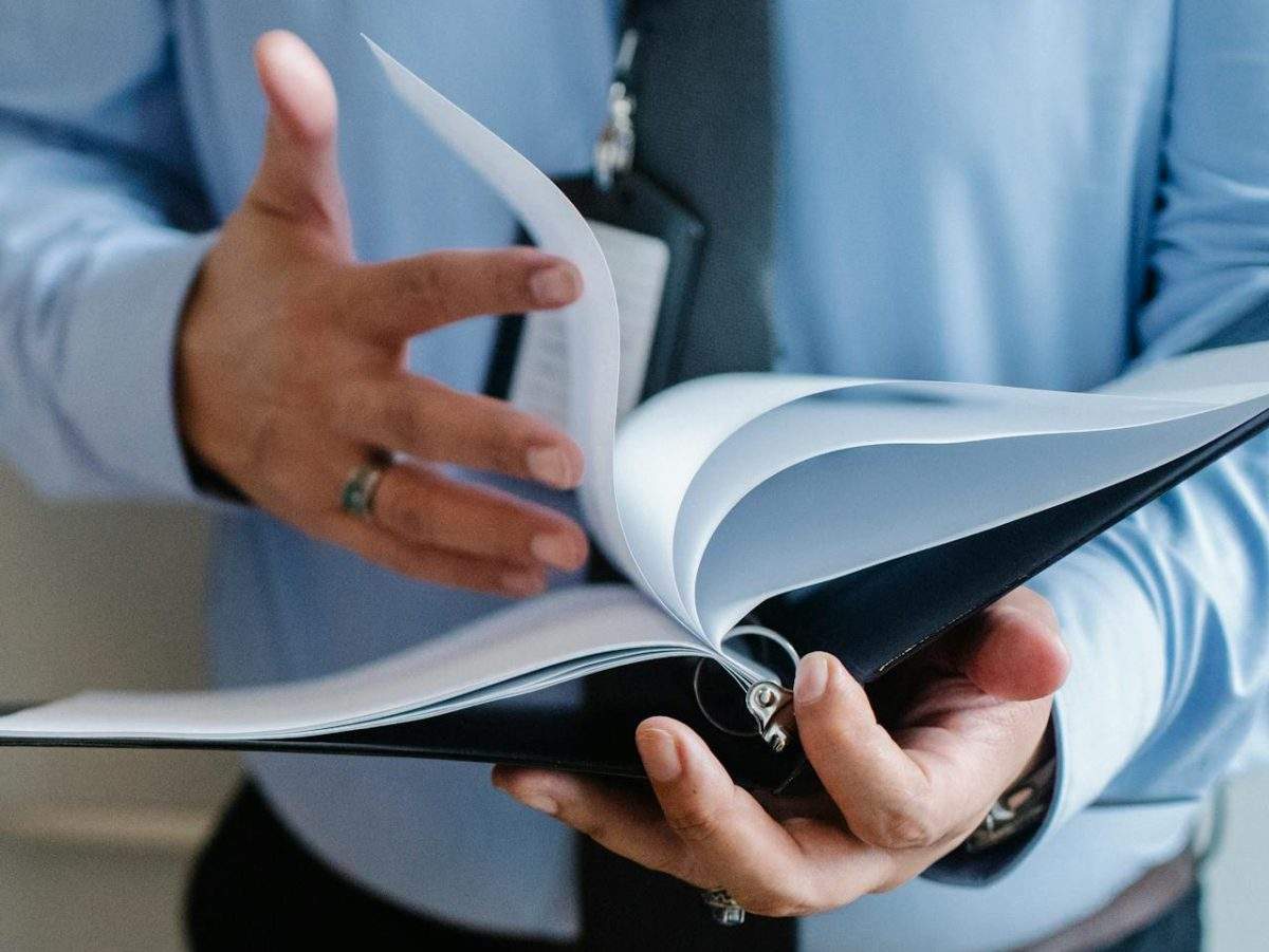 Man flipping through agency agreement book