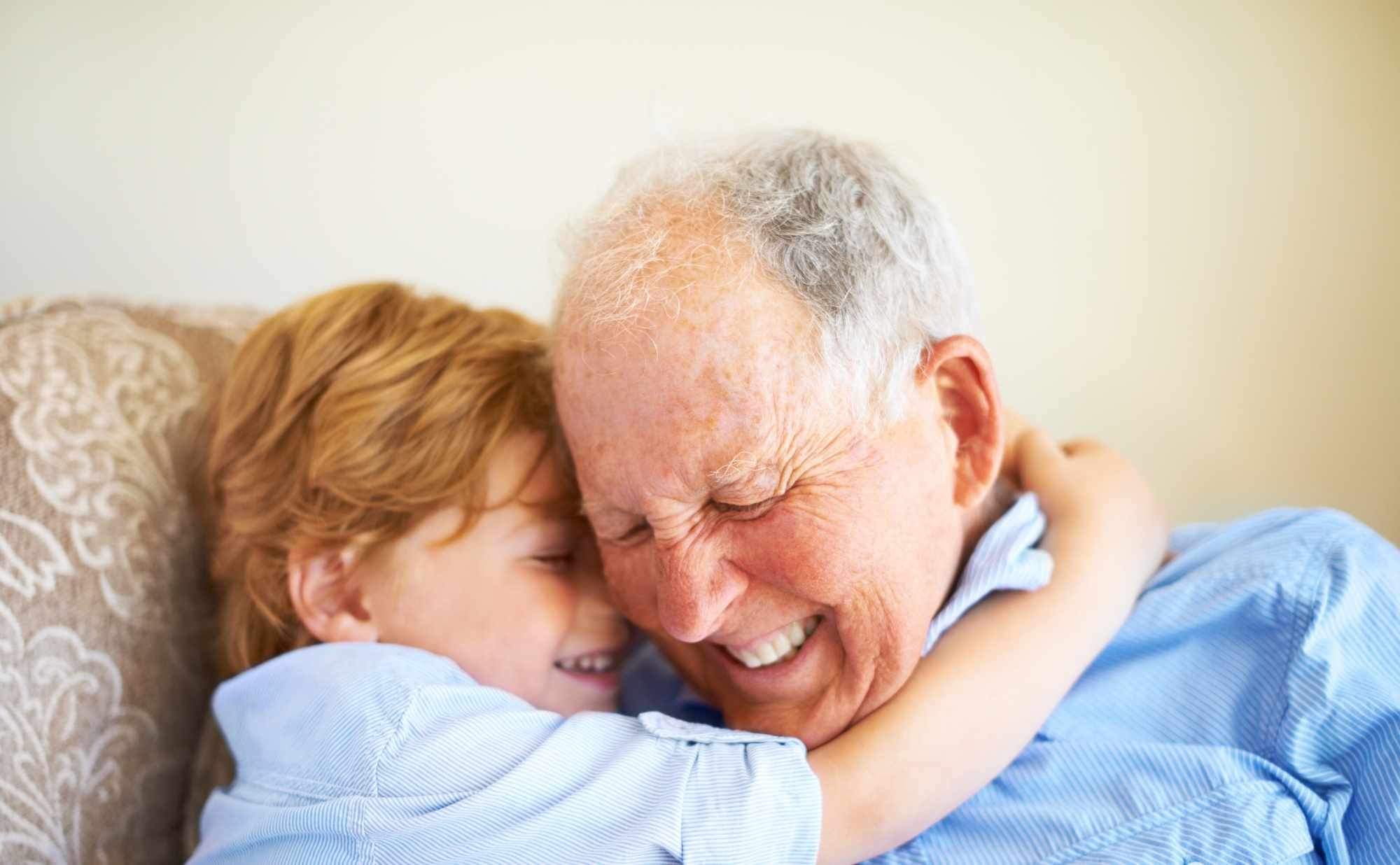 Grandad cuddling grandson whilst thinking about his will